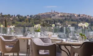 Tables dressées pour un repas d'exception avec vue sur le village médiéval, typique des restaurants de Saint-Paul-de-Vence.