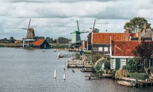 Moulins à vent et maisons traditionnelles au bord de l'eau, un paysage typique pour savoir quoi visiter en Hollande.