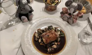 Deux peluches souris dégustent un plat de viande et champignons dans un restaurant Prague pas cher.