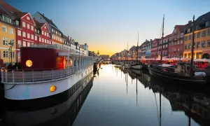 Canal de Nyhavn à Copenhague au coucher du soleil, avec des maisons colorées et des bateaux. Parfait pour un week-end copenhague.
