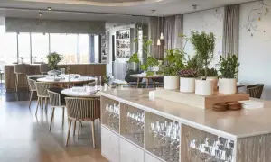 Ambiance élégante d'un restaurant à Copenhague, avec des tables dressées, des plantes et une vue sur le bar. Idéal pour découvrir les meilleurs restaurants Copenhague.