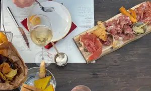Assiette de charcuterie et de fromage, vin blanc, chips et pain, dans un vignoble de la province de Grosseto.