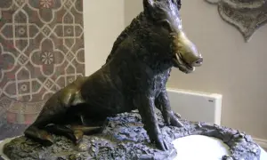Sculpture d'un sanglier, inspirée par l'art de Florence, posé sur un socle rocheux.
