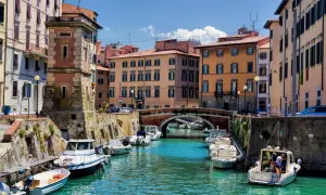 Canaux de Livourne, bateaux amarrés, bâtiments colorés et un pont. Idéal pour savoir que faire à Livourne.