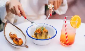 Un plat d'artichaut garni, des croquettes et un cocktail fruité dans un restaurant à Grenade.