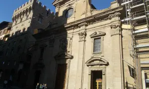 Façade de la basilique Santa Trinita à Florence, avec des échafaudages sur le côté droit. Des vélos sont garés devant.
