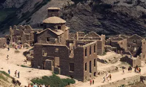 Ruines de pierre du lago di vagli, un village fantôme envahi par la végétation, avec des visiteurs explorant les vestiges.