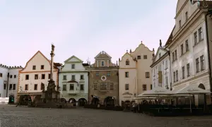 Place de la ville pavée avec une colonne baroque et des maisons colorées, parfait pour visiter la République Tchèque.
