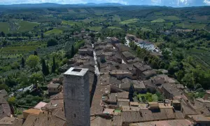 Vue aérienne de Panzano in Chianti, un village toscan pittoresque avec des toits de tuiles, des vignobles et des oliveraies verdoyantes.