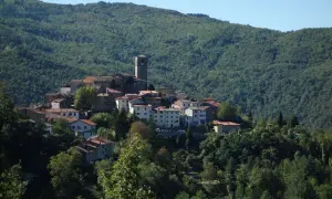 Village de San Marcello Pistoiese niché sur une colline verdoyante, avec son clocher dominant les toits de tuiles rouges.