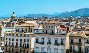 Vue panoramique de Palerme, avec ses bâtiments historiques et ses dômes sous un ciel bleu. Parfait pour un week-end à Palerme.