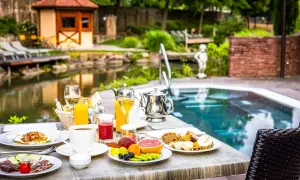 Petit-déjeuner copieux au domaine Moulin Ensisheim, avec vue sur la piscine et le jardin.