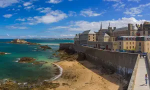 Un week-end à Saint-Malo : la cité corsaire vue depuis les remparts, avec la mer émeraude, le Fort National et la plage de sable fin.