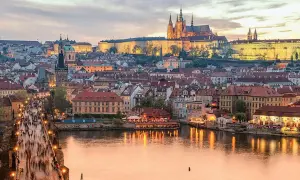 Prague en ce moment : le pont Charles animé, le château illuminé et la Vltava reflétant les lumières de la ville.