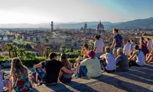 Vue panoramique de Florence depuis le Piazzale Michelangelo. Des touristes profitent du coucher de soleil sur la ville.