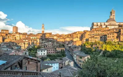 Vue panoramique de Sienne, idéale pour visiter Sienne en 2 jours. La ville médiévale s'étend sur une colline, dominée par le Duomo et ses tours.