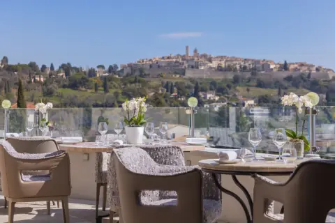 Tables dressées pour un repas d'exception avec vue sur le village médiéval, typique des restaurants de Saint-Paul-de-Vence.