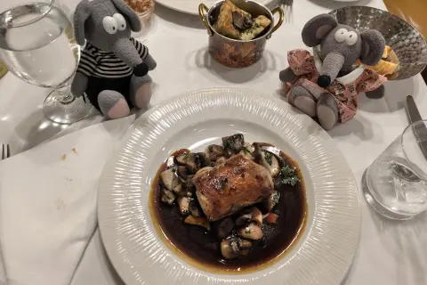 Deux peluches souris dégustent un plat de viande et champignons dans un restaurant Prague pas cher.