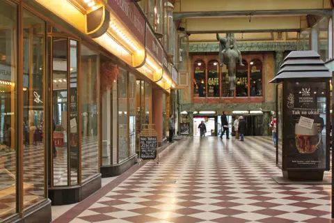 Passage Lucerna à Prague, avec son sol à damier, ses vitrines et une statue équestre.