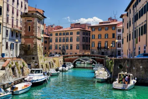 Canaux de Livourne, bateaux amarrés, bâtiments colorés et un pont. Idéal pour savoir que faire à Livourne.