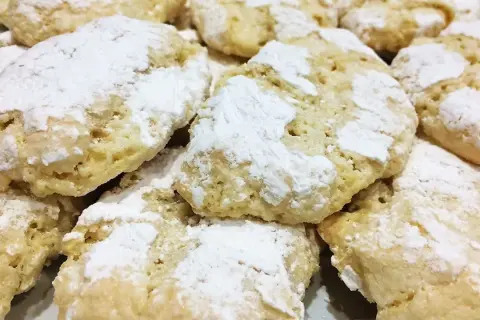 Gros plan sur des biscuits ricciarelli faits maison, saupoudrés de sucre glace. Une délicieuse recette à essayer !