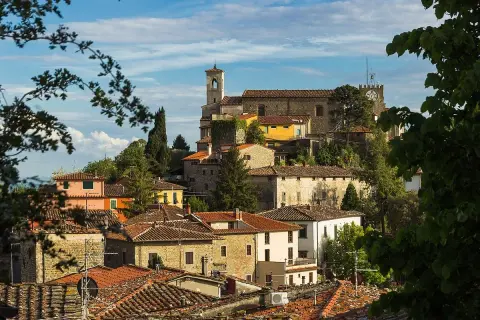 Vue panoramique de Montecatini Alto, avec ses toits de tuiles rouges et ses bâtiments anciens perchés sur une colline verdoyante.