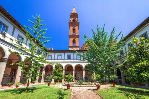Cour intérieure verdoyante avec fontaine et campanile de Santo Spirito à Florence.