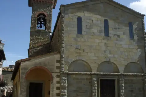Église romane et son clocher à Civitella in Val di Chiana, Toscane. Le soleil illumine les pierres anciennes.