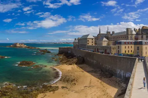 Un week-end à Saint-Malo : la cité corsaire vue depuis les remparts, avec la mer émeraude, le Fort National et la plage de sable fin.