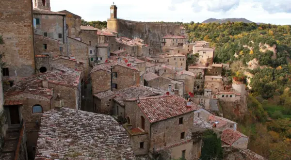 Vue panoramique de Sorano, Italie, un village médiéval perché sur une falaise, avec ses maisons en pierre et ses toits de tuiles rouges.