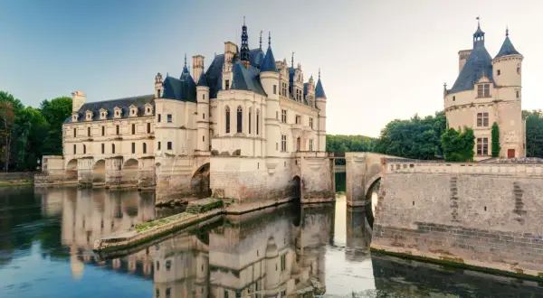 Le château de Chenonceau, joyau des châteaux de la Loire, s'avance sur le Cher, ses reflets dans l'eau évoquant une scène de conte de fées.
