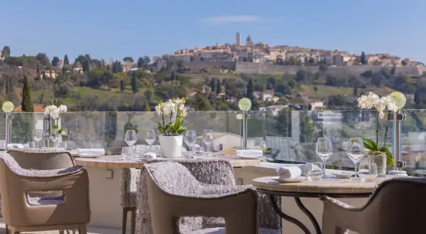 Tables dressées pour un repas d'exception avec vue sur le village médiéval, typique des restaurants de Saint-Paul-de-Vence.
