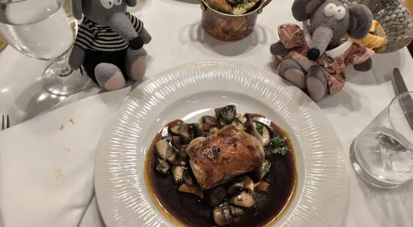 Deux peluches souris dégustent un plat de viande et champignons dans un restaurant Prague pas cher.