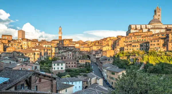 Vue panoramique de Sienne, idéale pour visiter Sienne en 2 jours. La ville médiévale s'étend sur une colline, dominée par le Duomo et ses tours.