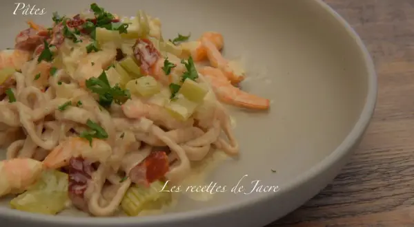 Pâtes à la toscane crémeuses avec crevettes, tomates séchées et céleri, garnies de persil frais. Un délice pour les gourmands.