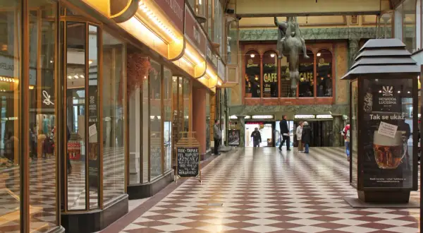 Passage Lucerna à Prague, avec son sol à damier, ses vitrines et une statue équestre.
