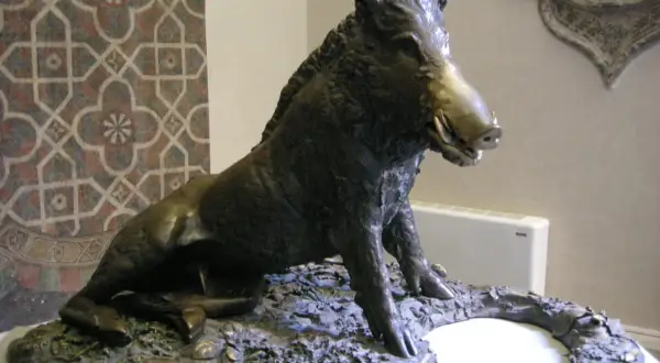 Sculpture d'un sanglier, inspirée par l'art de Florence, posé sur un socle rocheux.