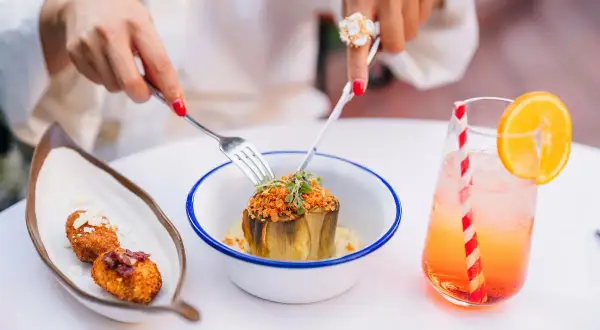 Un plat d'artichaut garni, des croquettes et un cocktail fruité dans un restaurant à Grenade.