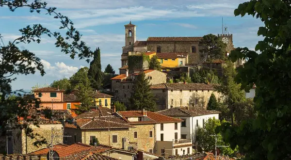 Vue panoramique de Montecatini Alto, avec ses toits de tuiles rouges et ses bâtiments anciens perchés sur une colline verdoyante.