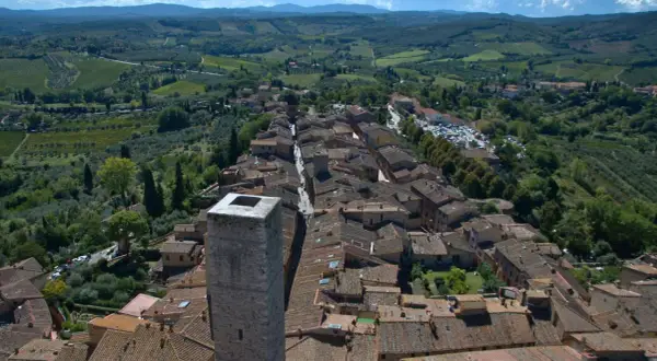 Vue aérienne de Panzano in Chianti, un village toscan pittoresque avec des toits de tuiles, des vignobles et des oliveraies verdoyantes.