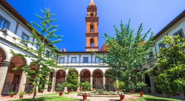 Cour intérieure verdoyante avec fontaine et campanile de Santo Spirito à Florence.