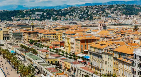Vue panoramique de Nice, avec ses toits orangés et la colline verdoyante en arrière-plan. Parfait pour un week-end nice.