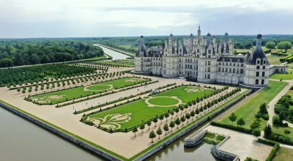 Le château de Chambord, un des plus célèbres châteaux en France, vu du ciel avec ses jardins à la française et la rivière.