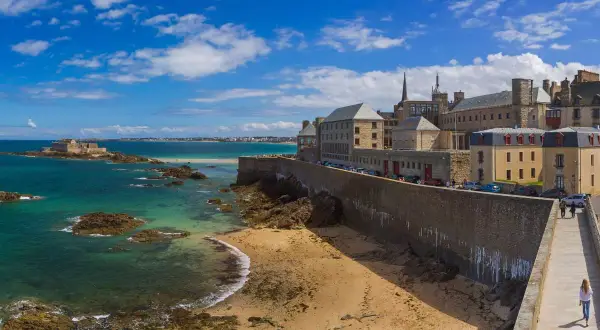 Un week-end à Saint-Malo : la cité corsaire vue depuis les remparts, avec la mer émeraude, le Fort National et la plage de sable fin.