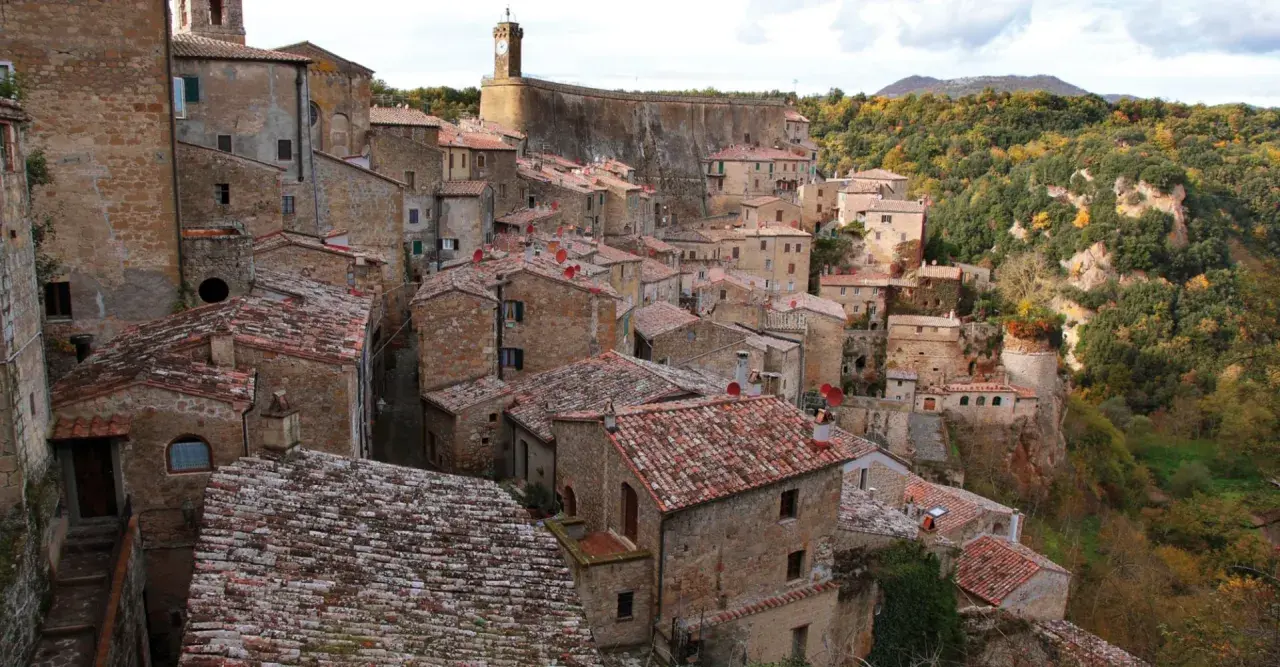 Vue panoramique de Sorano, Italie, un village médiéval perché sur une falaise, avec ses maisons en pierre et ses toits de tuiles rouges.