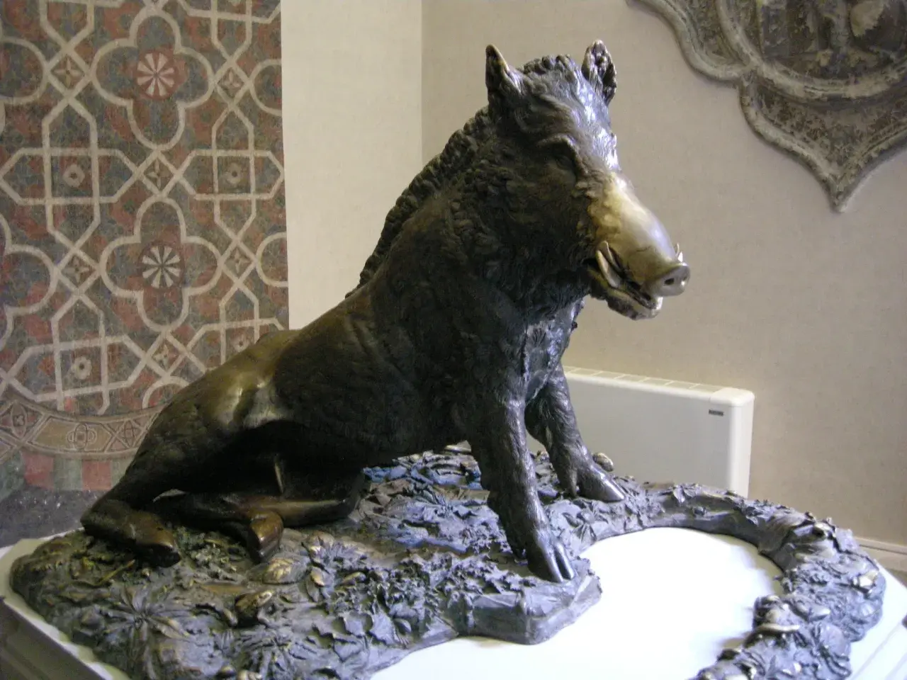 Sculpture d'un sanglier, inspirée par l'art de Florence, posé sur un socle rocheux.