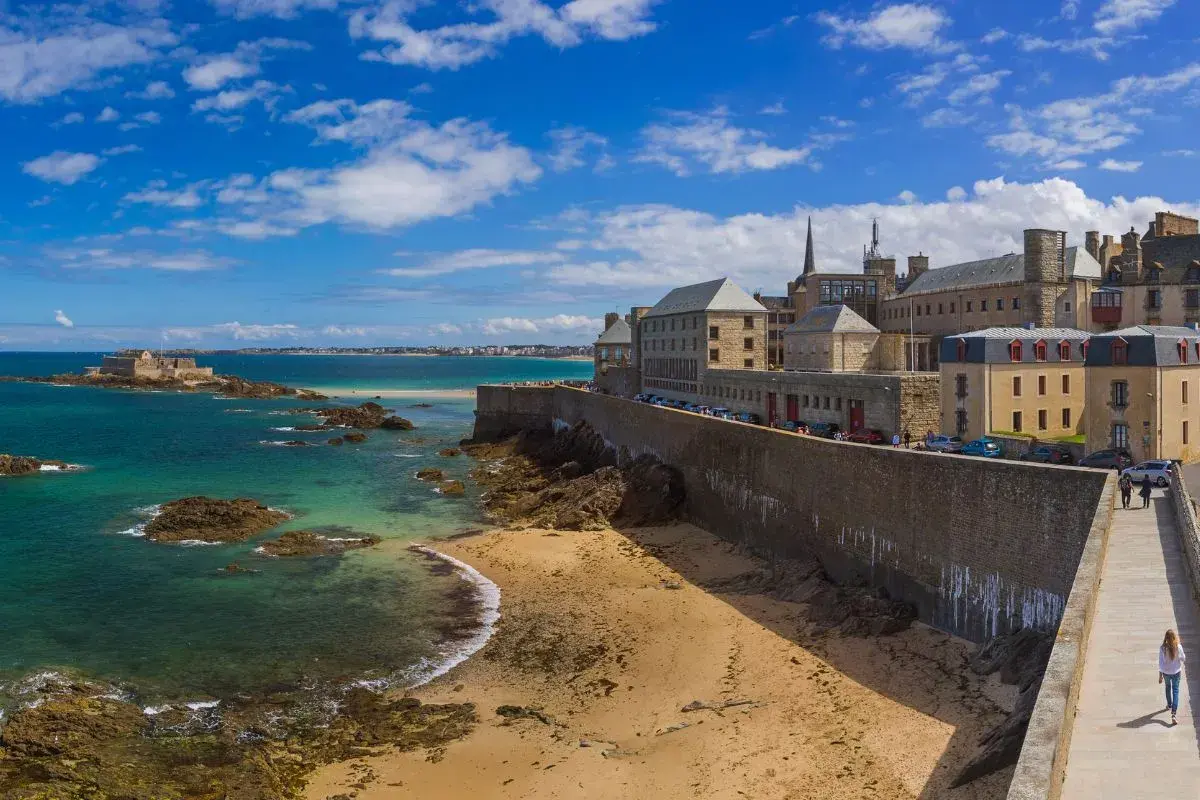 Un week-end à Saint-Malo : la cité corsaire vue depuis les remparts, avec la mer émeraude, le Fort National et la plage de sable fin.