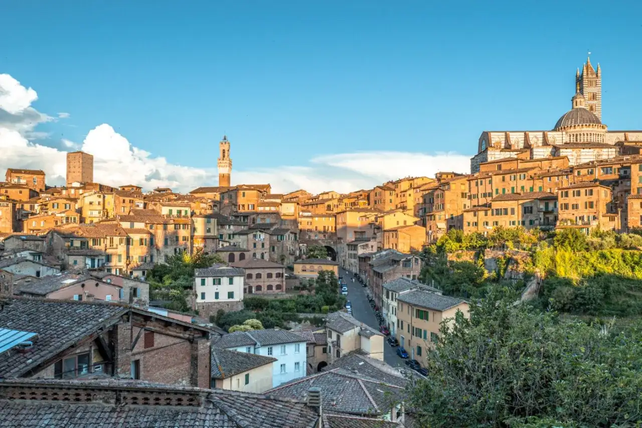 Vue panoramique de Sienne, idéale pour visiter Sienne en 2 jours. La ville médiévale s'étend sur une colline, dominée par le Duomo et ses tours.