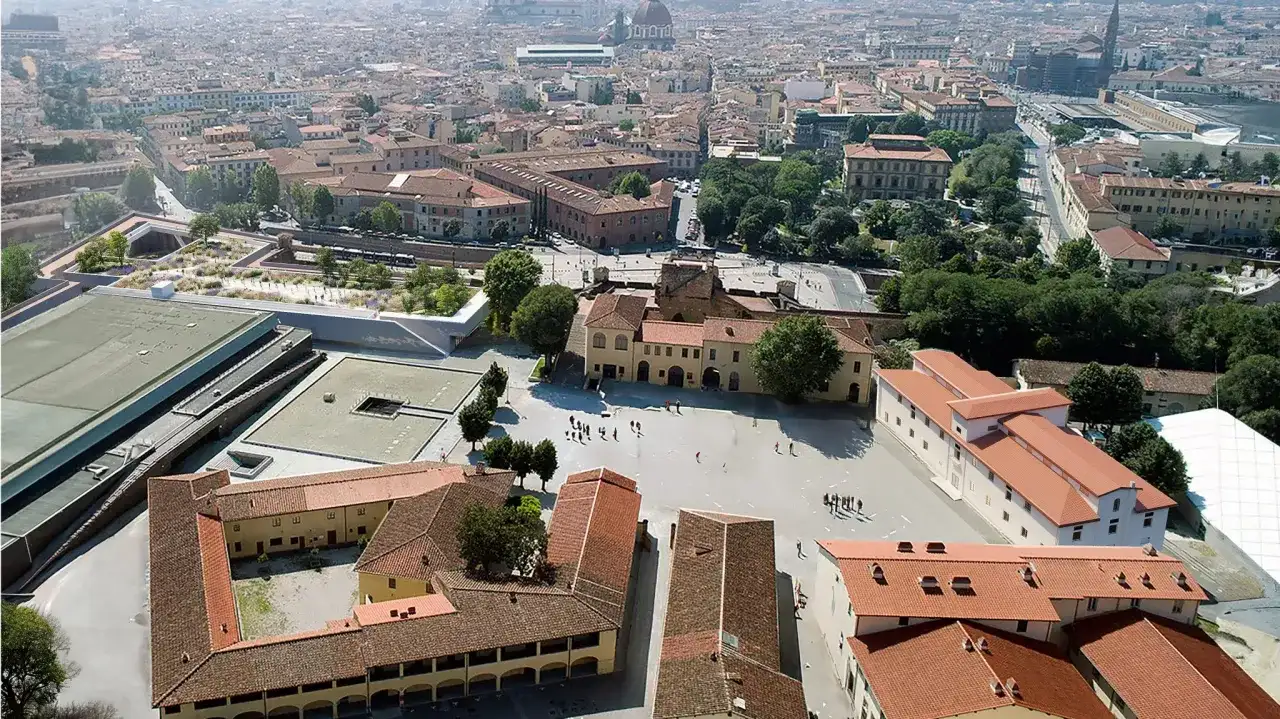 Vue aérienne d'une ville avec des bâtiments historiques et une nouvelle structure moderne, la Fortezza da Basso, ornée de verdure.