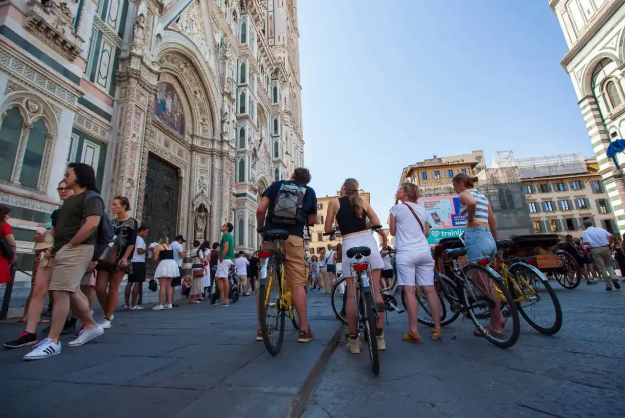 Des touristes &agrave; v&eacute;lo devant le Duomo de Florence. Un groupe explore la ville en v&eacute;lo, profitant de la beaut&eacute; de Florence.